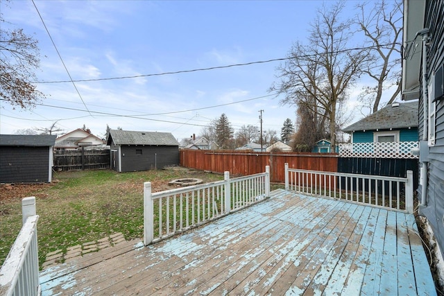 wooden terrace with a yard and a storage unit