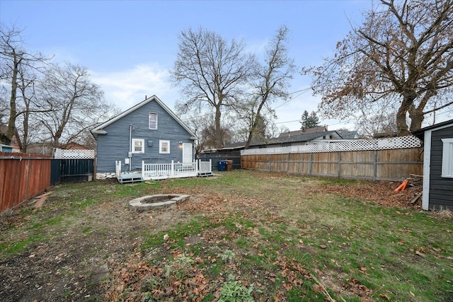 rear view of property with a fire pit and a deck