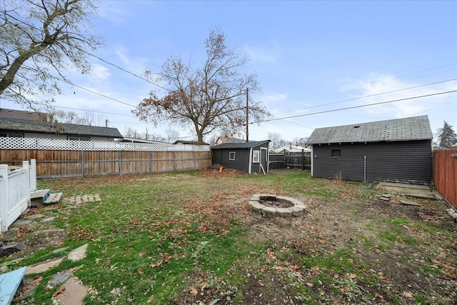 view of yard with a shed and an outdoor fire pit