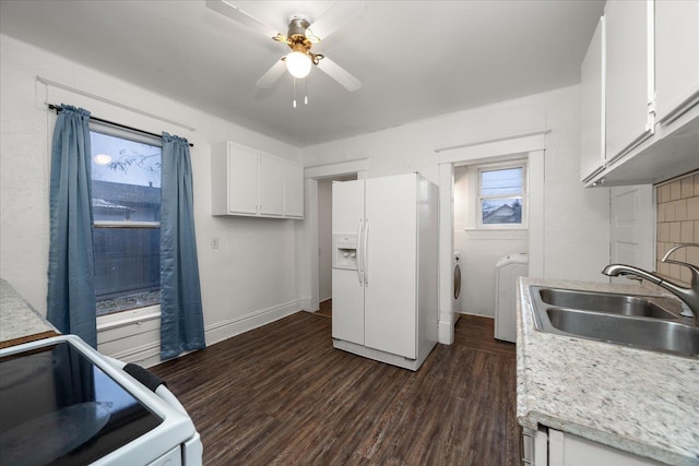 kitchen featuring white cabinets, stove, white refrigerator with ice dispenser, and sink