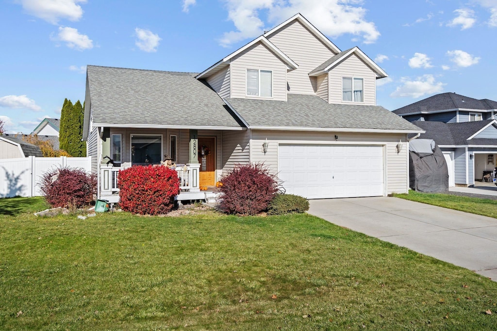 view of front of property featuring a front lawn, a porch, and a garage