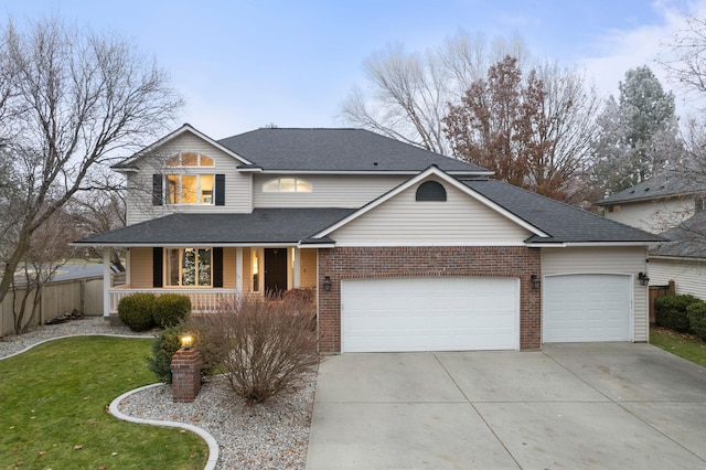 view of front property featuring a porch, a garage, and a front lawn