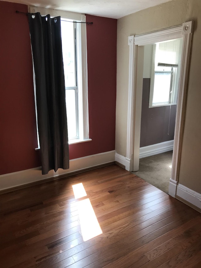 unfurnished room with hardwood / wood-style floors and a healthy amount of sunlight