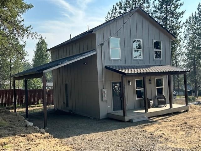 38105 N Frontage Rd, Elk, WA 99009 - view of front facade with board and batten siding, a porch, a carport, and a metal roof