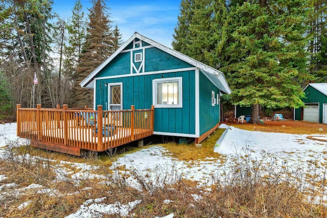 exterior space featuring an outbuilding, a garage, and a deck