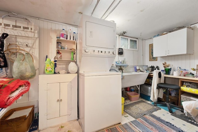 clothes washing area featuring stacked washer and clothes dryer