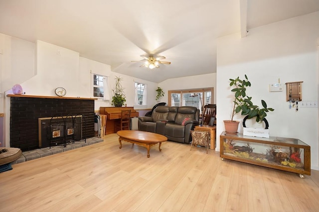 living room with light wood-type flooring, a brick fireplace, ceiling fan, and lofted ceiling