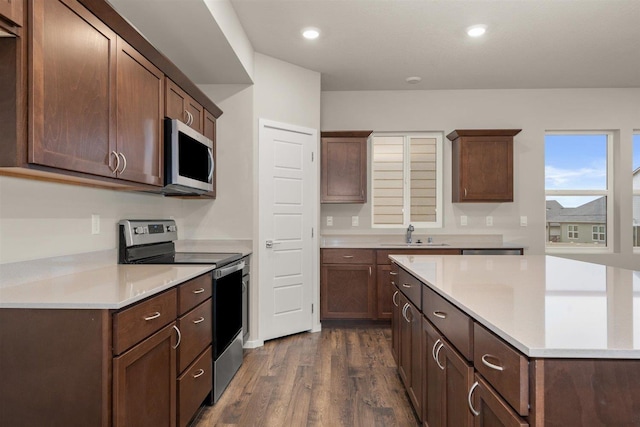 kitchen with dark brown cabinets, stainless steel appliances, dark hardwood / wood-style floors, and sink