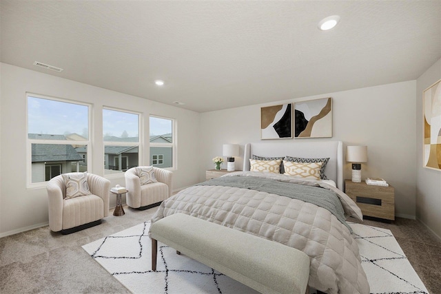 bedroom with light colored carpet and a textured ceiling