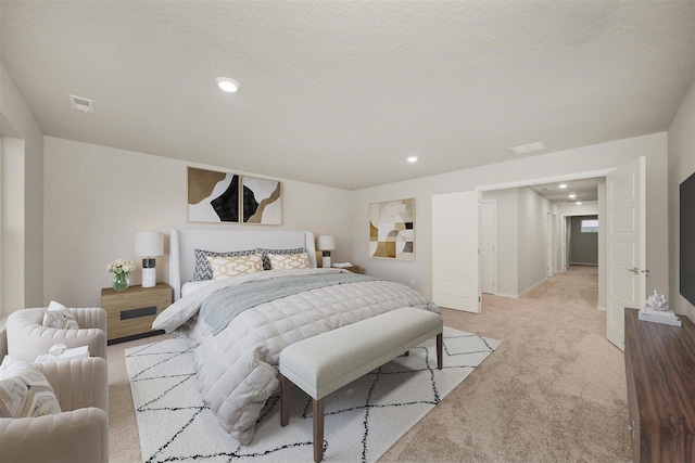 bedroom featuring light colored carpet and a textured ceiling