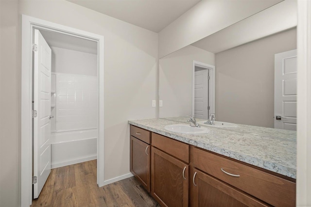 bathroom featuring wood-type flooring, vanity, and shower / bathtub combination