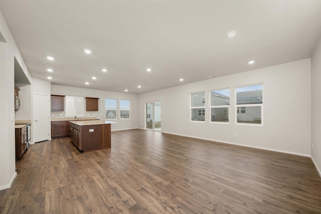 kitchen featuring dark hardwood / wood-style floors, a kitchen island, and a wealth of natural light