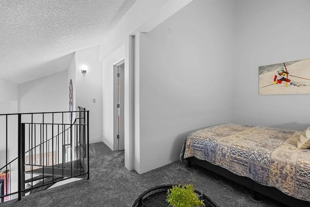 carpeted bedroom with a textured ceiling and vaulted ceiling