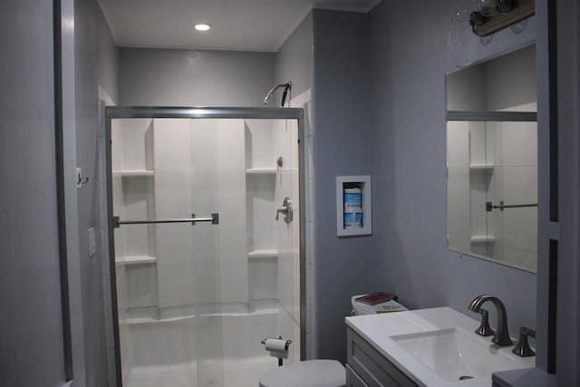 bathroom with vanity, toilet, and a shower with door