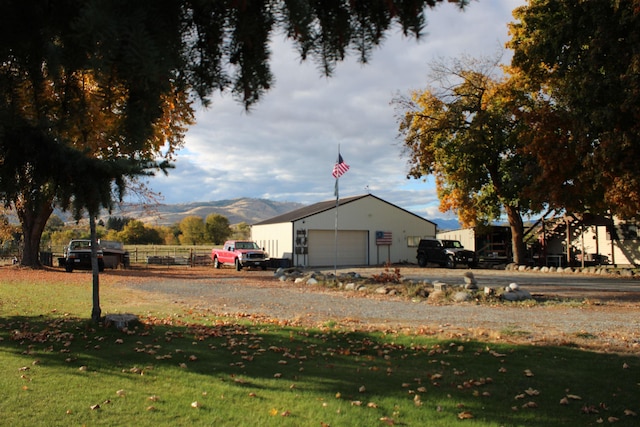 view of property's community featuring a mountain view, an outdoor structure, and a lawn