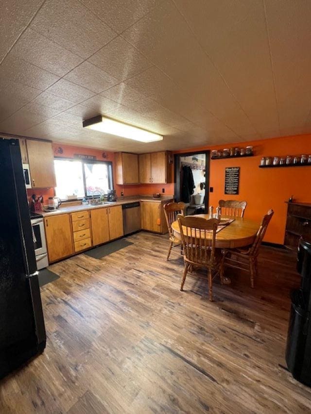 kitchen featuring white range with electric cooktop, light hardwood / wood-style flooring, black fridge, and stainless steel dishwasher