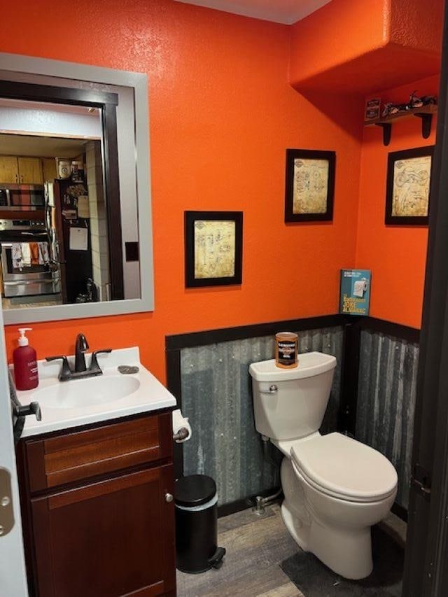 bathroom featuring hardwood / wood-style floors, vanity, and toilet