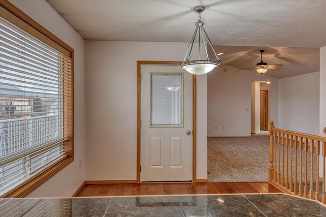 unfurnished dining area featuring hardwood / wood-style flooring, ceiling fan, and vaulted ceiling