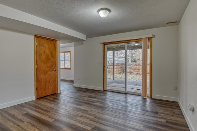 spare room with dark hardwood / wood-style flooring and a textured ceiling