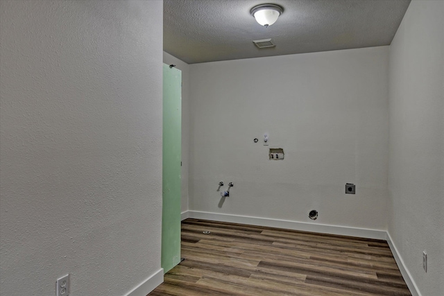 washroom with washer hookup, dark hardwood / wood-style flooring, a textured ceiling, gas dryer hookup, and electric dryer hookup