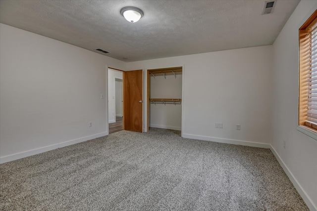 unfurnished bedroom featuring a closet, carpet, and a textured ceiling