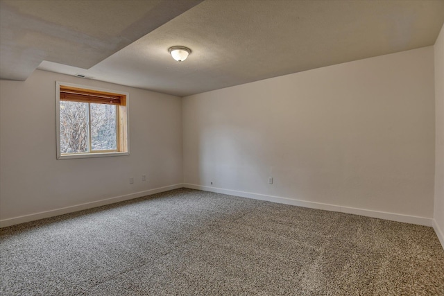 spare room with a textured ceiling and carpet floors