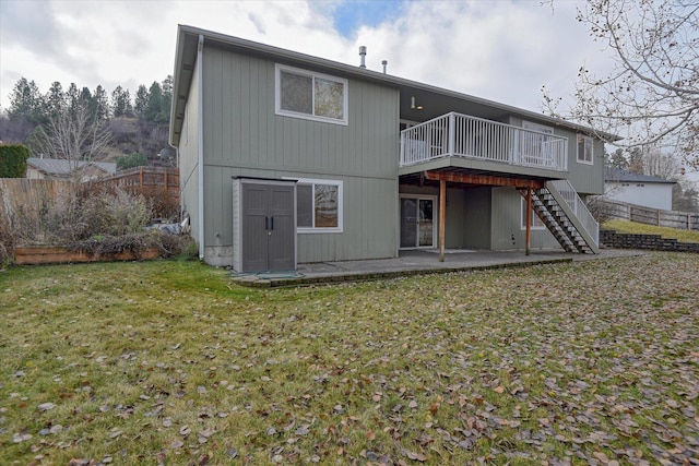 rear view of house with a lawn, a deck, and a patio