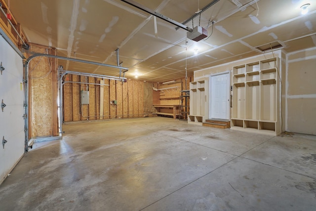 garage with a garage door opener and electric panel