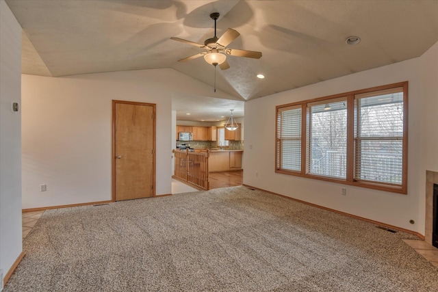 unfurnished living room with ceiling fan, light carpet, and vaulted ceiling