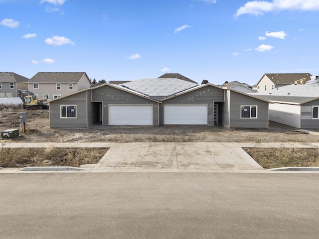 view of front of home with a garage, a residential view, and concrete driveway