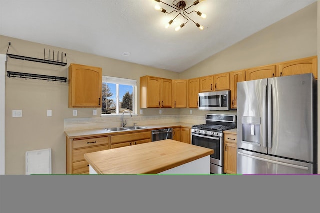 kitchen featuring lofted ceiling, sink, light brown cabinets, and appliances with stainless steel finishes