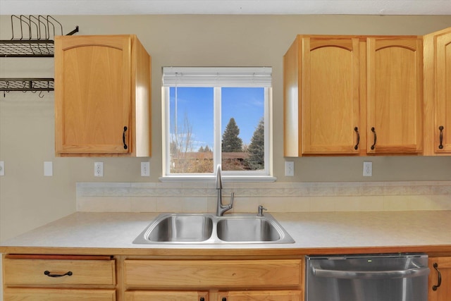 kitchen with dishwasher, sink, and light brown cabinetry