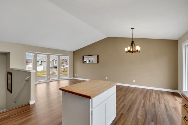 kitchen featuring light hardwood / wood-style floors, decorative light fixtures, a notable chandelier, butcher block countertops, and white cabinetry