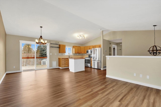 kitchen with tasteful backsplash, hanging light fixtures, appliances with stainless steel finishes, and a chandelier