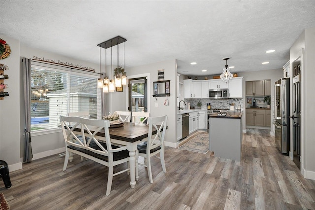 dining space with hardwood / wood-style floors, a textured ceiling, and sink