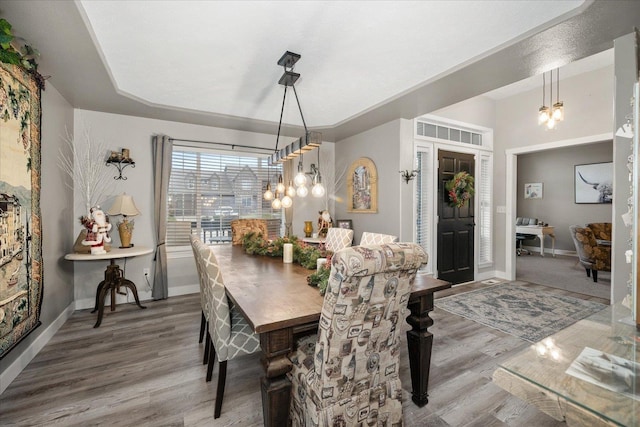 dining space featuring hardwood / wood-style flooring and a notable chandelier