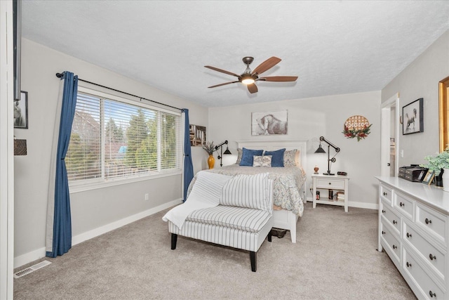 carpeted bedroom with a textured ceiling and ceiling fan