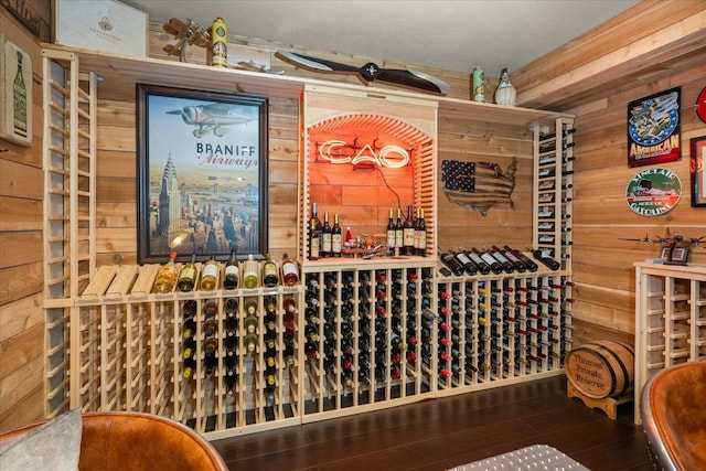 wine area featuring a textured ceiling, hardwood / wood-style flooring, and wooden walls