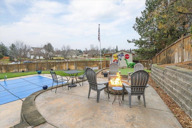 view of patio / terrace with a covered pool and an outdoor fire pit