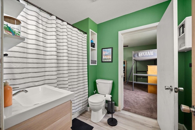 bathroom featuring vanity, hardwood / wood-style flooring, and toilet