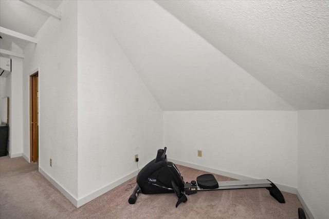 workout room featuring a textured ceiling, light colored carpet, and lofted ceiling