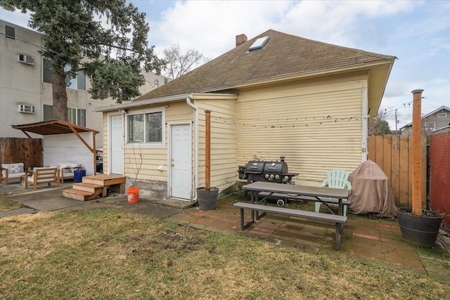 rear view of house featuring a patio area and a yard