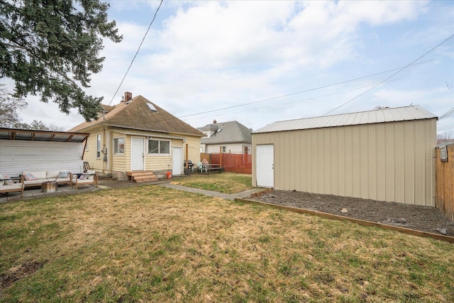 rear view of property with an outdoor structure and a lawn