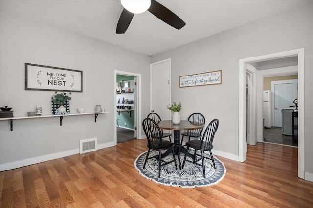 dining area with hardwood / wood-style flooring and ceiling fan