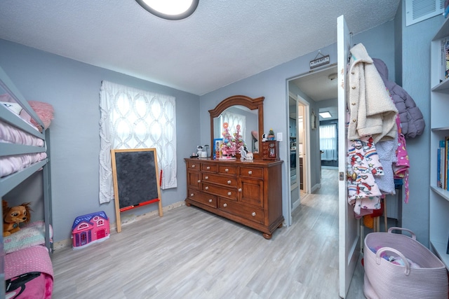 bedroom featuring light hardwood / wood-style floors and a textured ceiling