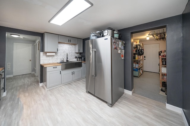 kitchen with gray cabinets, butcher block counters, sink, decorative backsplash, and high end fridge