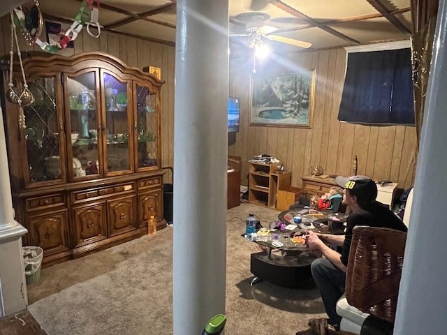 interior space with wood walls, carpet, and ceiling fan