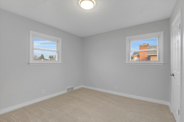 unfurnished room featuring light carpet