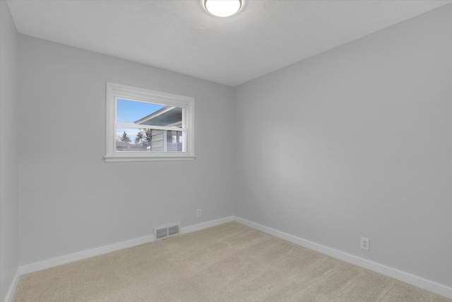 carpeted empty room featuring a textured ceiling