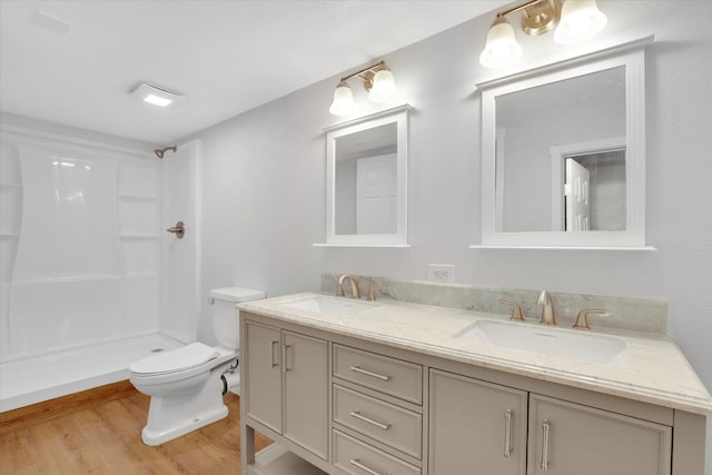 bathroom featuring hardwood / wood-style flooring, vanity, toilet, and a shower